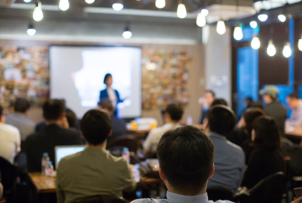 Audience Watching a Presentation. Defocused Blurred Presenter Du