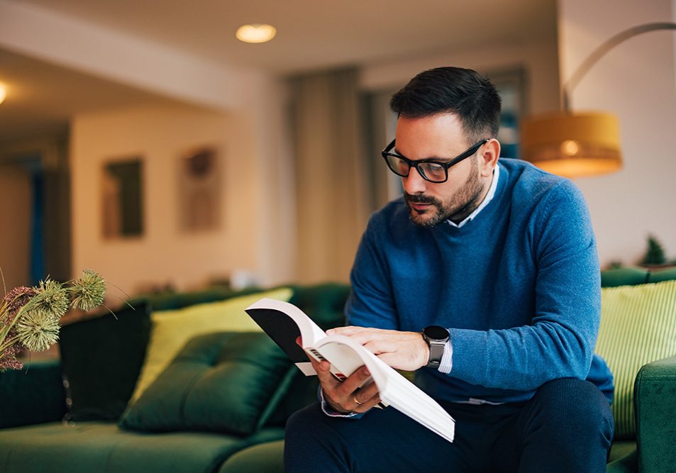 Businessman with glasses on, reading a book.